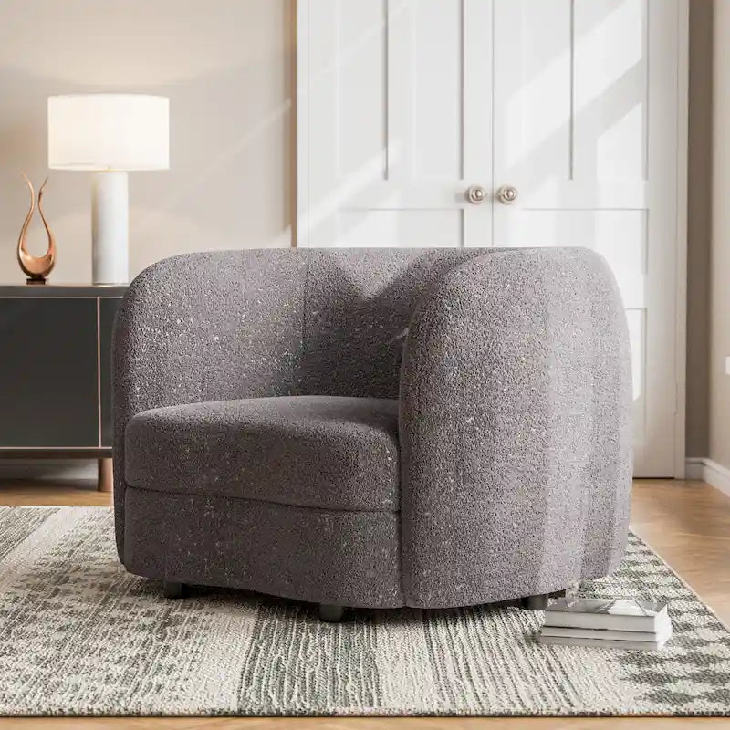 Poltrona moderna in bouclé con braccioli curvi, seduta a rene e gambe rotonde in legno